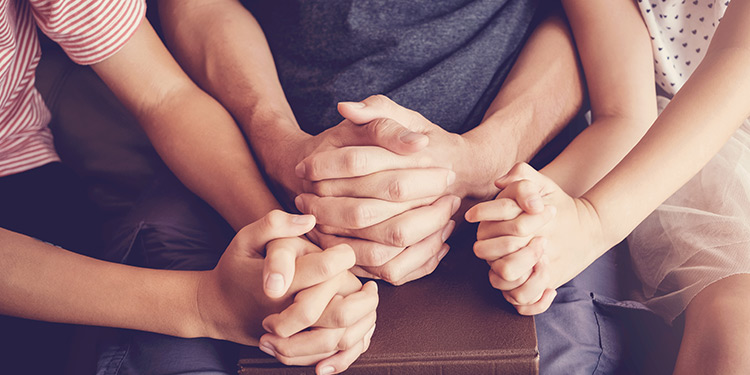 Closeup of family praying together