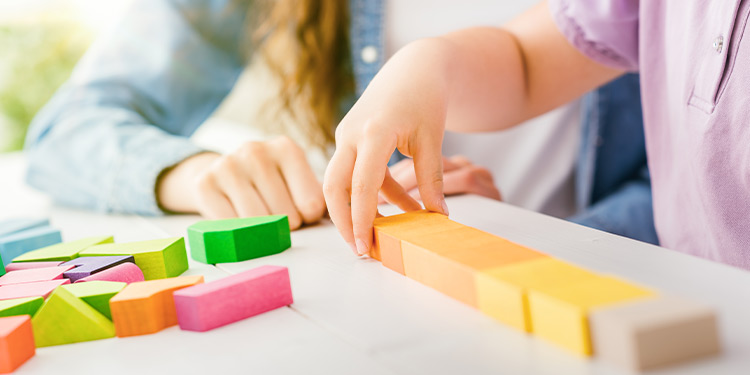 Closeup of child playing with colorful wooden blocks