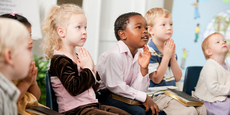 Young students sit and pray