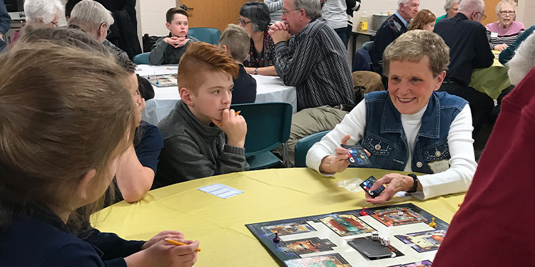 Kids and senior members of Saint Francis play board games together